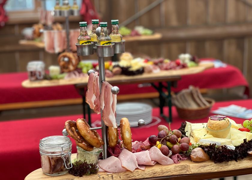 Pretzel con selección de quesos y uvas entre los platos de la Festhalle Bayernland